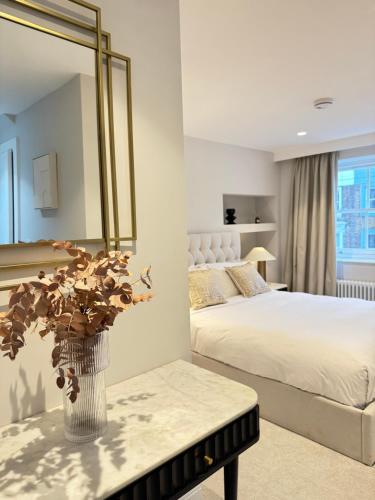 a bedroom with a bed and a mirror and a table at Comfort 3 Bedroom Home in Notting Hill in London