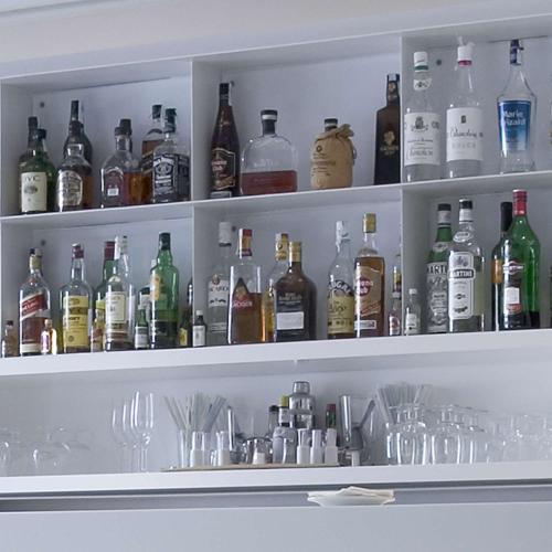 a shelf filled with lots of bottles of alcohol at NH Bogota Urban 93 Royal in Bogotá