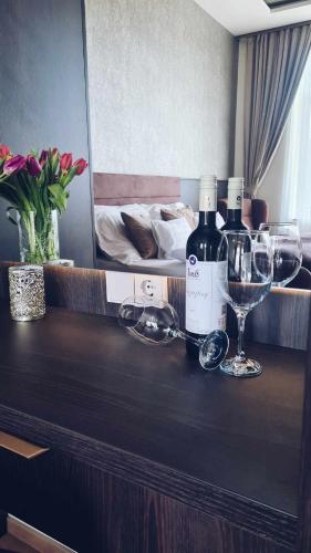 a counter with two bottles of wine and glasses at Vöröskő Villa -ELNÖKI szauna és jakuzzi használattal in Balatonalmádi
