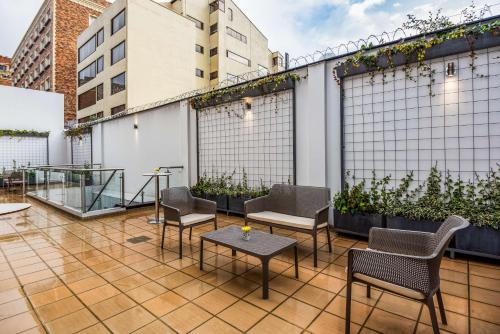 a patio with chairs and tables on a building at NH Bogota Urban 93 Royal in Bogotá
