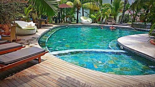 a large swimming pool with people in the water at Ocean Villas Apart Hotel in Grand Baie