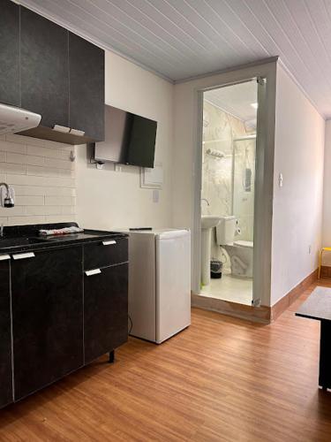 a kitchen with black cabinets and a white refrigerator at Loft e Suites Temporada in Balneário Camboriú