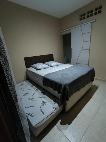 a bedroom with two beds and a door to a closet at Pousada chc in Praia Grande
