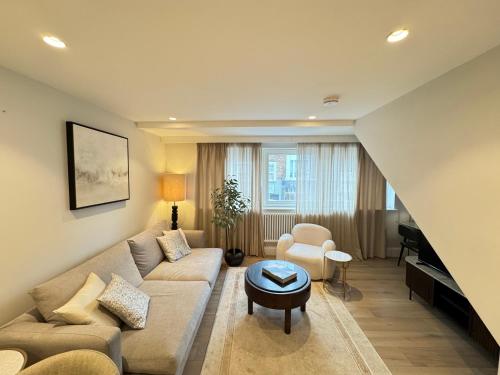 a living room with a couch and a piano at Comfort 3 Bedroom Home in Notting Hill in London