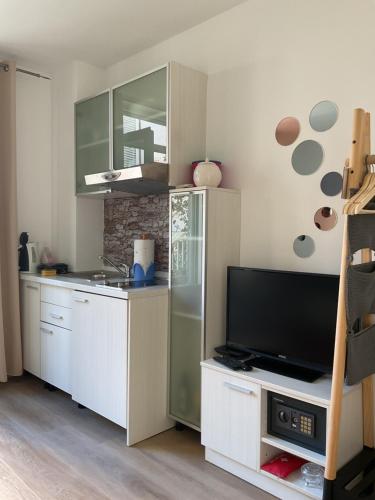 a kitchen with a refrigerator and a tv at Studios Lulic in Makarska
