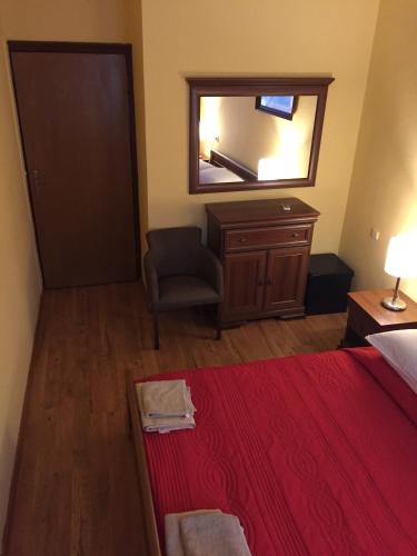 a bedroom with a bed and a mirror and a chair at Villa Miramare , Dobrota seafront in Kotor