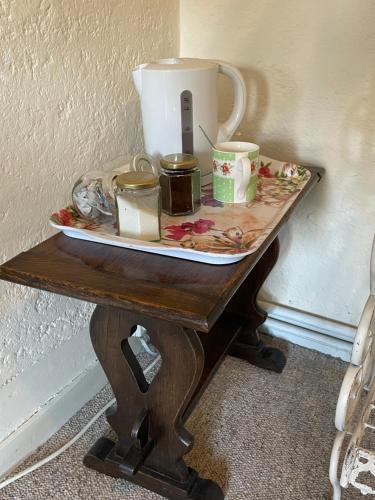 a table with a tea pot and candles on it at The Bridge Street Historic Guest House in Sudbury