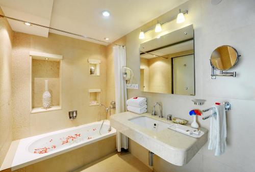 a bathroom with a sink and a bath tub at The Luxant Hotel in Bengaluru