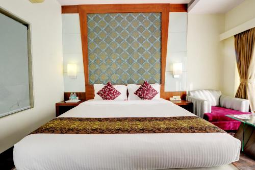 a bedroom with a large white bed with red pillows at The Luxant Hotel in Bengaluru