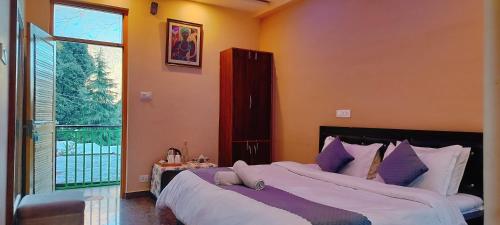 a bedroom with a large bed and a large window at Lill Sparrow by Verdant escapes hospitality in Dharamshala