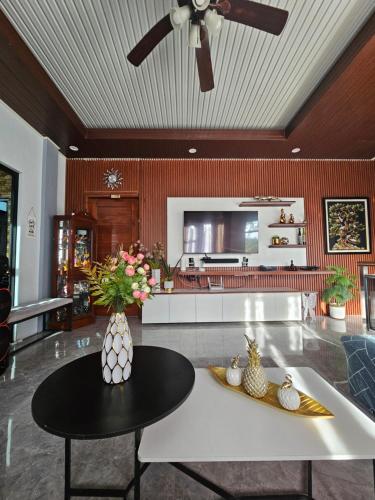 a living room with a ceiling fan and a table at Goldland Caelestis Guest House in Bacolod