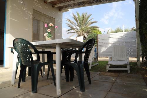 a table and four chairs on a patio at Rocca dei tramonti in Punta Braccetto
