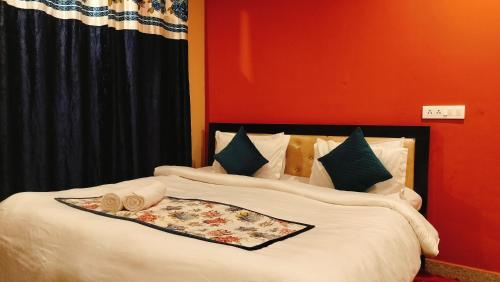 a bedroom with a large white bed with a red wall at Lill Sparrow by Verdant escapes hospitality in Dharamshala