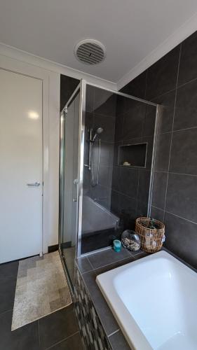 a bathroom with a shower and a bath tub at Family hideaway in Wodonga