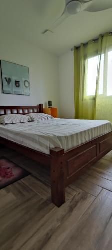 a bed with a wooden frame in a bedroom at Villa la fournaise in Le Tampon