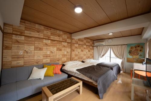 鹿児島市にあるKaibundo Apartment Hotelのベッドとソファのある寝室