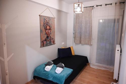 a room with a bed with a painting on the wall at Mavi's Hub in Larisa