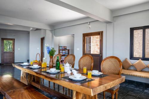 a dining room with a wooden table and chairs at Lazy Hills by Xplore Indo in Kotagiri