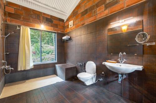 a bathroom with a toilet and a sink at Lazy Hills by Xplore Indo in Kotagiri