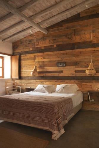 a bedroom with a large bed with wooden walls at Muxima - Aljezur in Aljezur