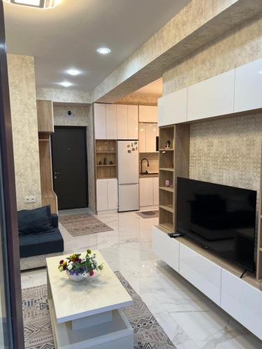 a living room with a large television and a couch at Apartment for rent in Tbilisi City