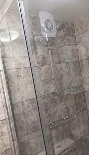 a shower with a glass door in a bathroom at 3 Guests - 1 Bedroom in Erith