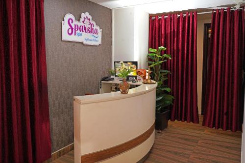 a salon with red curtains and a reception desk at KGA Elite Continental Hotel in Thiruvalla