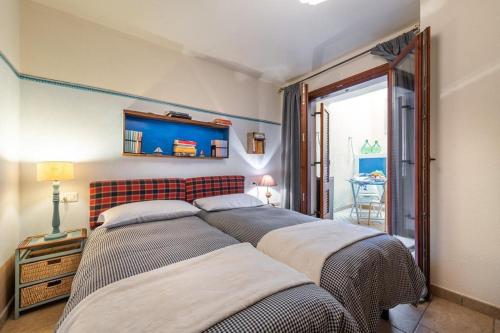 a bedroom with two beds and a window at Sea view garden in Cala Gonone
