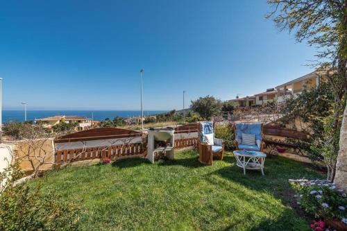 a yard with two chairs and a fence at Sea view garden in Cala Gonone