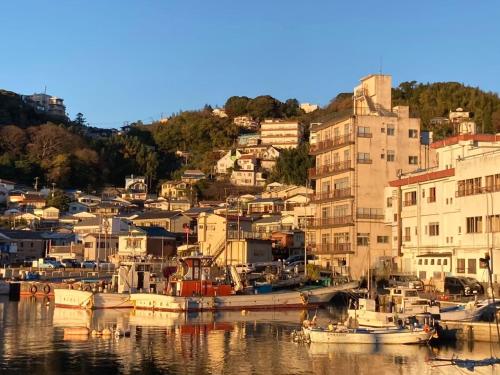 a group of boats are docked in a harbor at 個室101ダブルベッド1台駅徒歩6分Atami Hakoneも近いゲストハウス真鶴 in Manazuru