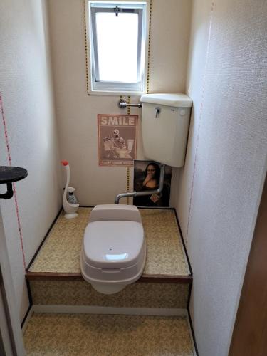 a small bathroom with a toilet and a window at 個室101ダブルベッド1台駅徒歩6分Atami Hakoneも近いゲストハウス真鶴 in Manazuru
