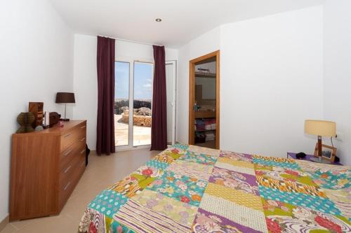 sypialnia z łóżkiem, komodą i oknem w obiekcie Ficula Nou Beachfront Villa with private pool w mieście Punta Grossa