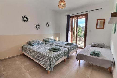 une chambre avec deux lits et une fenêtre dans l'établissement Maison U CASTAGNU, à Santa-Reparata-di-Balagna