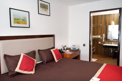 a hotel room with a bed and a bathroom at KGA Elite Continental Hotel in Thiruvalla