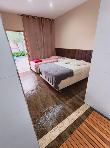 a bedroom with two beds and a large window at Pousada chc in Praia Grande