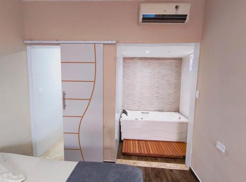 a bathroom with a sink and a bath tub at Pousada chc in Praia Grande