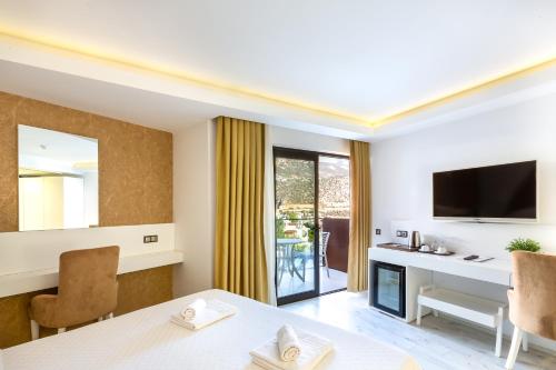 a living room with a dining table and a television at Rhapsody Hotel & Spa Kalkan in Kalkan