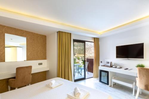a room with a dining table and a television at Rhapsody Hotel & Spa Kalkan in Kalkan