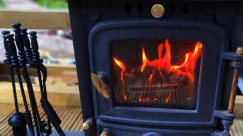 a blue stove with a fire in it at Loch Lomond Hideaways- Luxury Cabins with Jacuzzis in Drymen