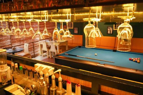 a pool table in a bar with lights and bottles at KGA Elite Continental Hotel in Thiruvalla