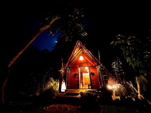 a small house is lit up at night at Chika's Place River View Udawalawa in Udawalawe