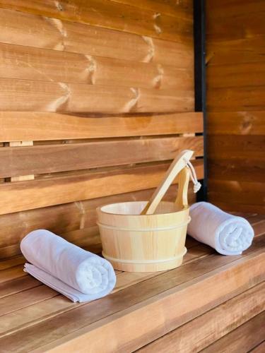 a mortar and pestle and two rolled towels next to a bucket at Vöröskő Villa- TITKÁRI szauna és jakkuzi használattal in Balatonalmádi