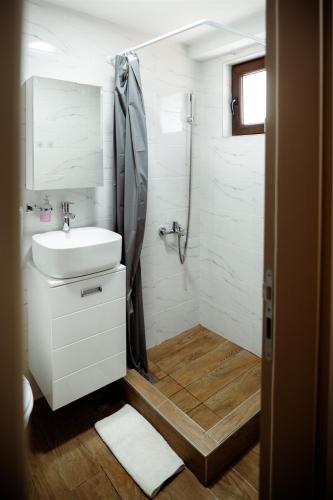 a white bathroom with a sink and a shower at CROWNE Stan11550 Sopstveno Parking Mesto in Lazarevac