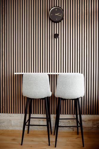 a table with two chairs and a clock on a wall at CROWNE Stan11550 Sopstveno Parking Mesto in Lazarevac