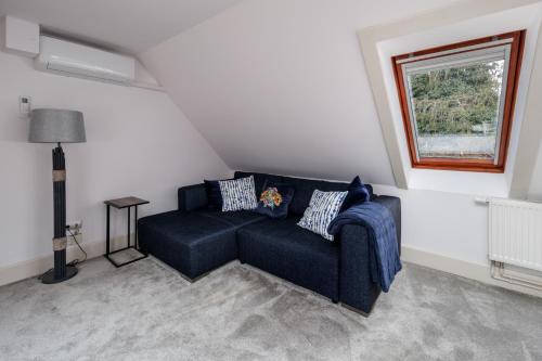 a living room with a blue couch and a window at Uhu Villa 750 m2 - Budapest in Budapest