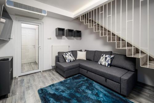 a living room with a couch and a staircase at Uhu Villa 750 m2 - Budapest in Budapest