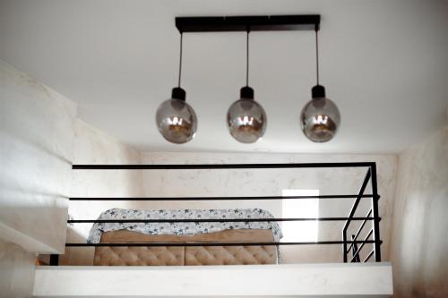 a room with three lights hanging from the ceiling at CROWNE Stan11550 Sopstveno Parking Mesto in Lazarevac