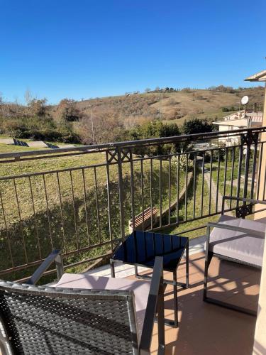 a balcony with chairs and a view of a hill at Smile in Manciano