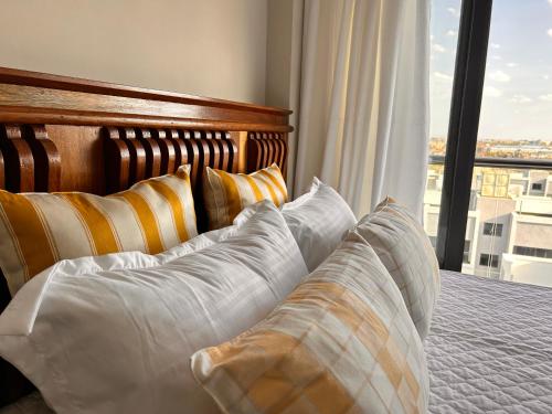 a bedroom with a bed with pillows and a window at Mimah's cozy getaway near JKIA at Taurus Residences in Nairobi