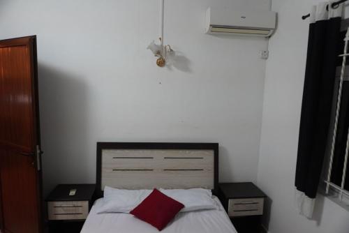 a bedroom with a bed with a red pillow at LKH Appt Adam Garden Villa in Grand Baie